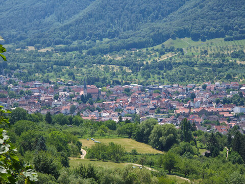 germany, charming dettingen an der erms town with church surrounded by vibrant green valley beneath perfect summer blue sky near metzingen