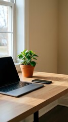 Fototapeta premium Laptop and smartphone on wooden desk with potted green plant by bright window, neutral beige wall background, modern workspace setup for remote work and productivity.