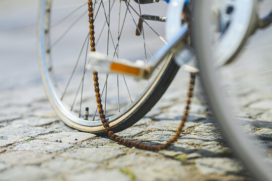 Low angle closeup of bicycle wheel and rusty chain.