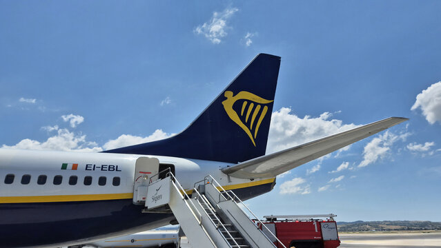 The tail fin of a Ryanair plane showing the gold harp logo and an attached boarding stairway. Picture taken on June 28, 2026 in Thessaloniki, Greece.
