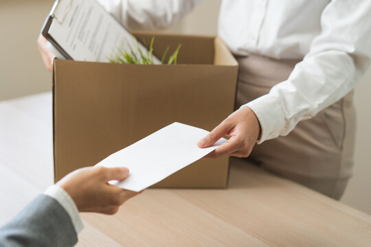 Unemployment quitting job, desperate asian young business woman send resignation letter to boss, resigning from company,holding belongs, pack stuff in box, layoff or leaving, changing work employment