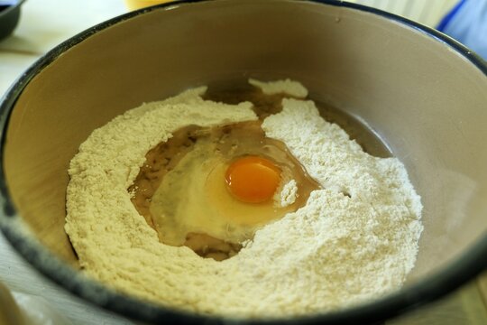 Baking ingredients mixing bowl with flour and raw egg
