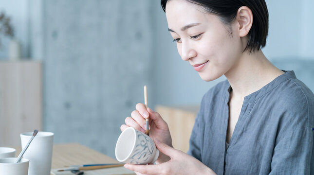アトリエで陶芸の絵付けをする女性のライフスタイル
