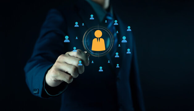 Businessman holding digital human resource icon with employee profiles, symbolizing recruitment, HR management, staff selection, corporate workforce strategy, and human capital development in modern.