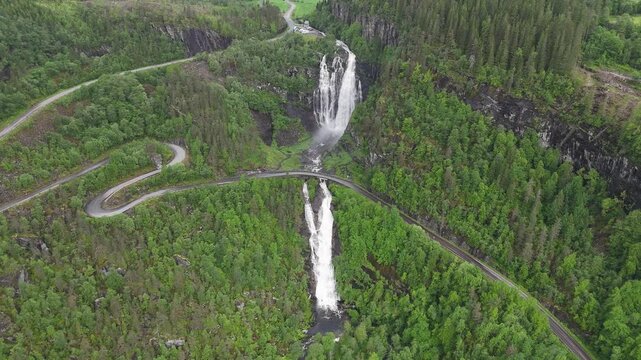 Aerial drone pan left to right flyover of Skjervsfossen with mountain background, Norway