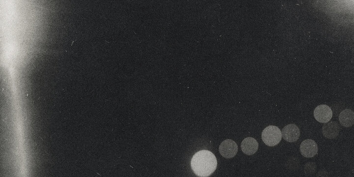 Defocused circular lights with grainy texture black and white photographic effect bokeh monochrome light spots