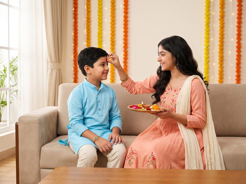 happy indian brother and sister celebrating raksha bandhan with traditional tilak ceremony representing sibling affection family togetherness blessings and festive cultural bonding at home