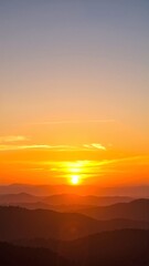 Fototapeta premium the sun sets over the mountains in the distance