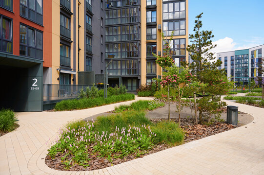 Modern residential complex with landscaping. Urban living, green spaces, and contemporary architecture.