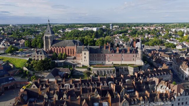 Dynamic aerial footage showcasing the Chateau de Gien and its surrounding historic town center in Gien, France. The video captures the prominent castle, a large church, and traditional French
