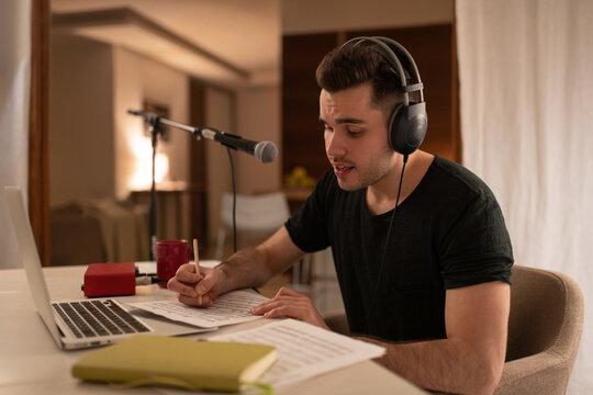 Male composer listening to music and making notes. Man work at home