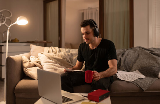 Male musician reading notes during online lesson