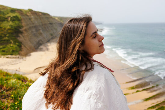 Woman travel portrait on ocean cliffside