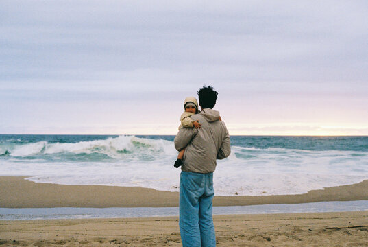 Travel Lifestyle Film Photo of Man Holding Child on Beach at Sunset