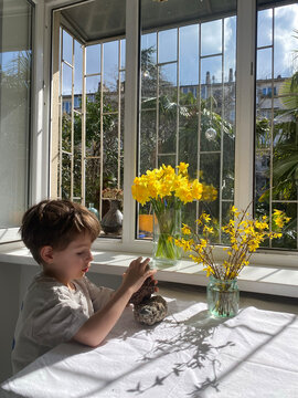 Toddler Playing With Flowers At The Table
