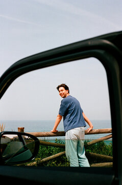 Man by Car at Ocean Fence Travel Film Photo
