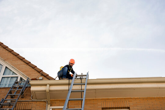 Worker performing rooftop installation and maintenance service