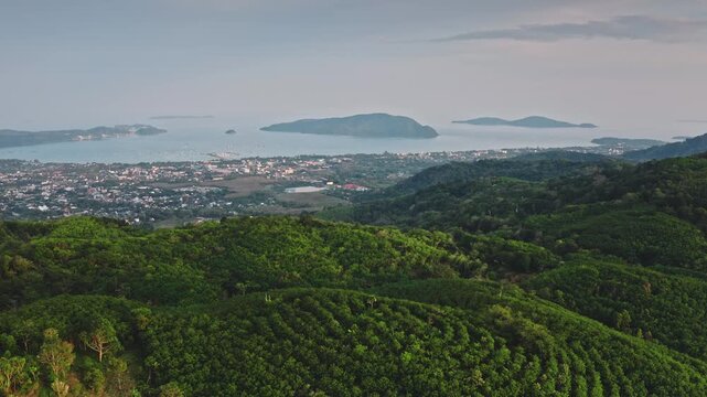 Phuket Island panorama, lush tropical mountains and turquoise Andaman Sea, coastal town and harbor with boats, clear sky and serene island landscape for travel and nature themes. Aerial drone panorama