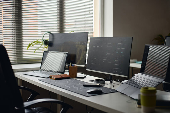 Wide shot of modern workstation displaying laptop and dual monitors, supporting multitasking and digital workflow. Ideal for remote work, tech startup, productivity marketing