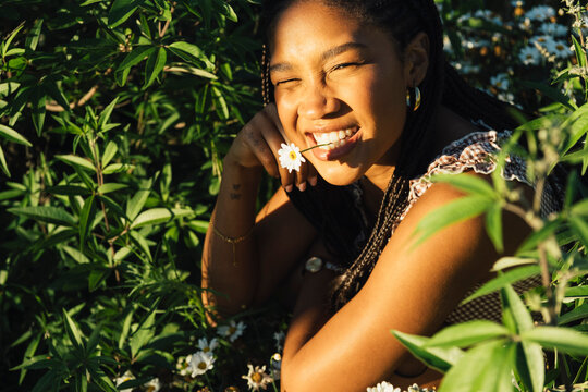Young woman surrounded by greenery in warm evening light