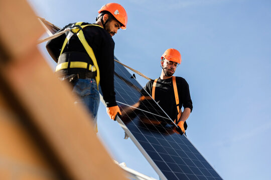 Workers installing solar panels on a rooftop for renewable energy