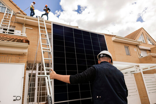 Installing solar panels on house roof for clean energy
