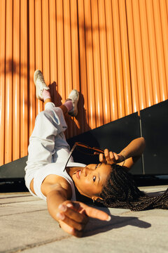 Young woman leaning on colorful urban structure