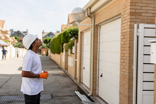 Handyman inspecting building while working outdoors