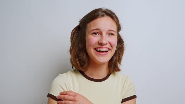 authentic and joyful laughter of a young woman with braces, eyes closed in pure happiness, celebrating positive emotions and genuine amusement