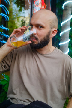 Man Drinks Beer in an Outdoor Pub Setting