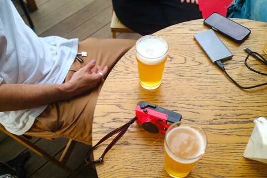 Friends Enjoy Drinks at a Table With a Camera and Phone
