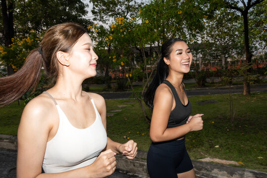 Women Jog Together in Park During Sunny Day