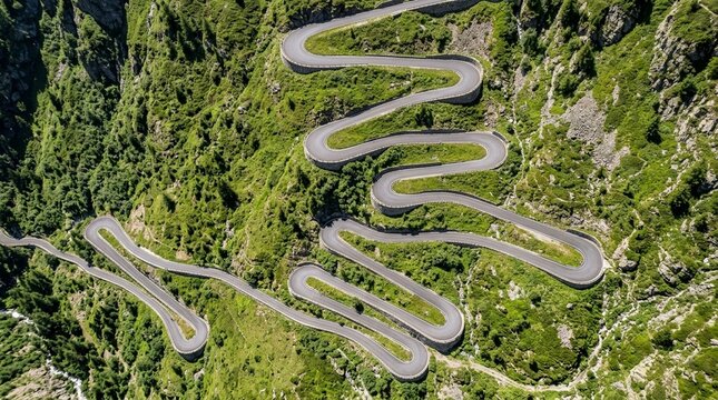 Tour De France Style Mountain Route Switchback Road from Aerial Drone View Looking Straight Down the Hairpin Bends Visible on a Green Alpine Mountainside