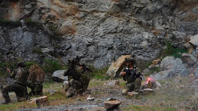 A group of soldiers in military uniforms were seen holding BB guns, cleaning their weapons and resting during a patrol while exercising their military training, playing games