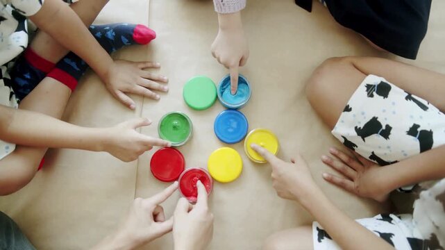 Children playing with colorful plastic container lids on the floor together
