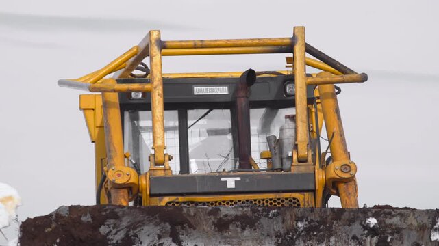 construction vehicle operating in snowy landscape side view yellow black industrial cold winter work natural light clean background copy space modern bright dark warm cool vivid dramatic.