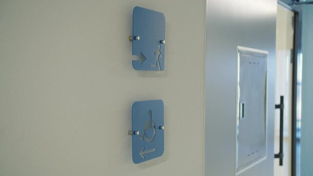 Accessibility and emergency exit signs on apartment hallway wall