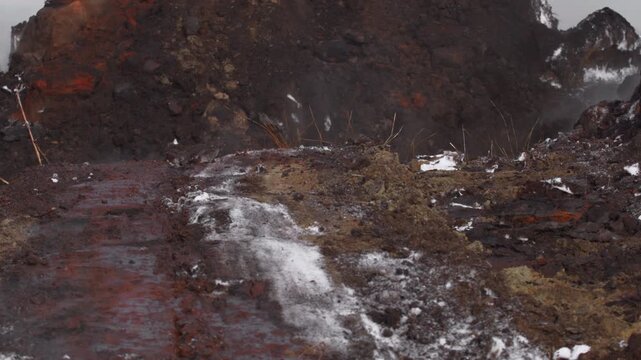 dramatic volcanic eruption with intense lava flow and close-up perspective on igneous rock field in natural disaster setting with red and brown tones and dramatic mood.