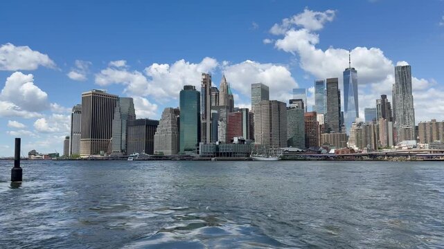 Panoramic, scenic view of Lower Manhattan. Financial district. Motion of East River waves. Cars traffic on FDR drive, road. New York City, United States