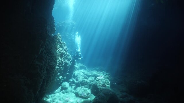 cave diving underwater scuba divers exploring caves and having fun ocean scenery sun beams and rays background
