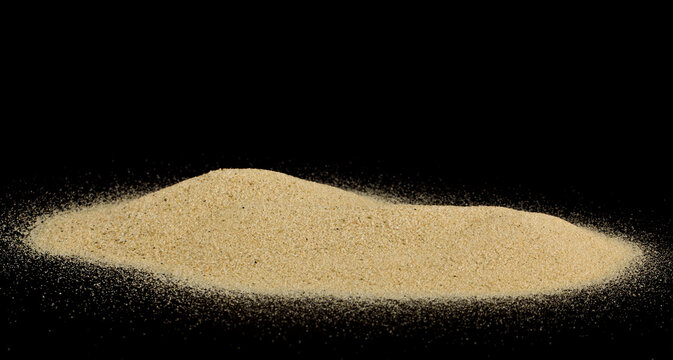 Pile of sand isolated on black background.