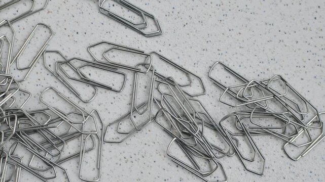 Paper clips intertwined in chaos on a bright surface, a visual representation of disordered creativity.