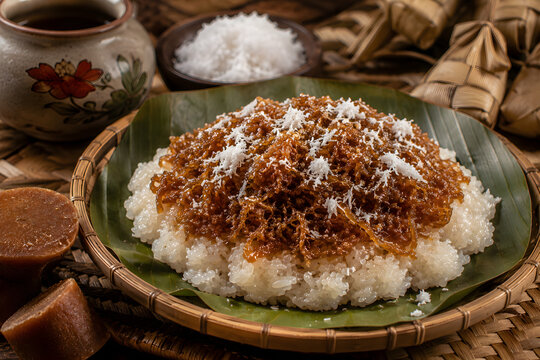 Pulut Inti Gula Kelantan is a traditional glutinous rice dessert topped with caramelized palm sugar and grated coconut, offering rich sweetness and authentic heritage flavors.
