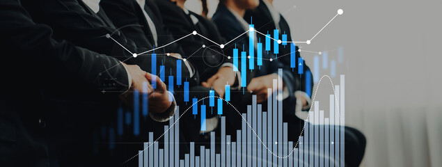 A group of business professionals engaged in a meeting, with financial charts and graphs overlaying...