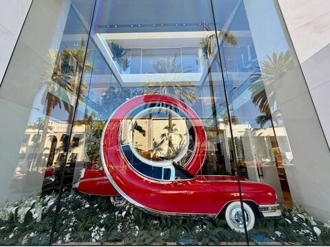 House of Dior on Rodeo Drive in Beverly Hills surrealist window display partnership with British artist Alex Chinneck on iconic American street symbols of a looping red car