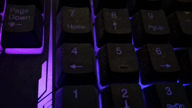 Gaming keyboard numeric keypad with glowing purple light motion video clip