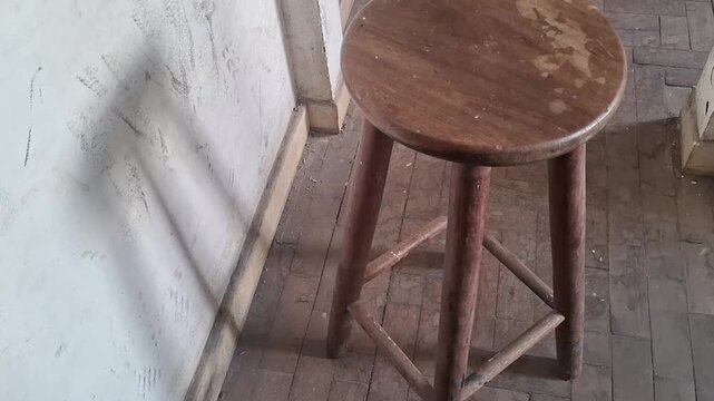 Old wooden stool standing on textured brick floor video animation motion