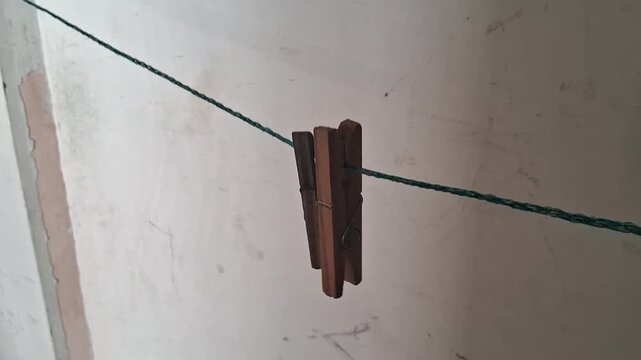 Wooden clothespin hanging on a simple string in motion video