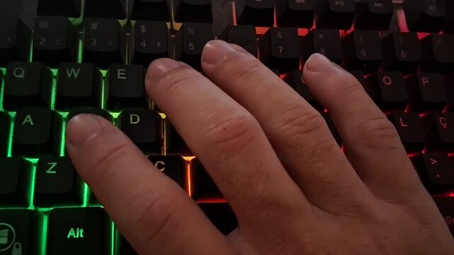 Human hand typing on glowing mechanical keyboard in motion video footage