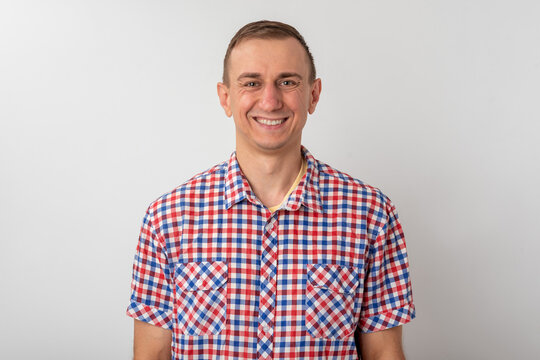 Smiling man finding happiness and confidence, exuding a friendly and approachable feel while standing against a clean, plain background, conveying a sense of well being and positive emotion